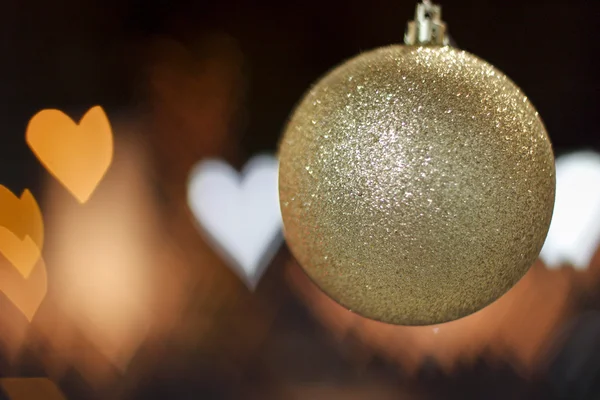 金色圣诞球与几个灯在心的形状 — 图库照片