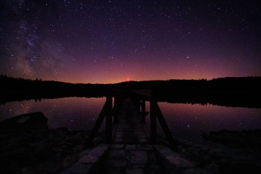 Göl kenarındaki iskele, akşam gökyüzü manzarası.