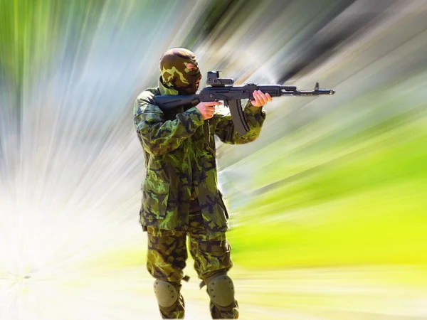 Airsoft boy with ak47, hard zoom-blurred background — Stock Photo, Image