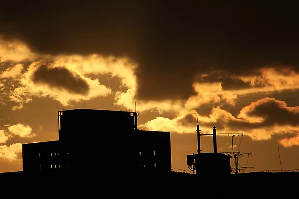 Cime di edifici silhouette nel bagliore del tramonto — Foto Stock