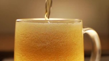 Bir kupa bira döküyor