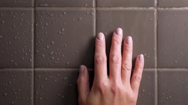 魅力的なブルネットの中年の女性はシャワーを浴びます。女は髪を洗う。裸の体。壁にグレーのタイル。皮膚の世話をします,日常的なホームトリートメント. — ストック動画