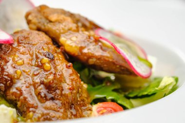 Dejon hardallı soslu ızgara sığır eti ve gri arka planda bir tabakta yumuşak peynir..