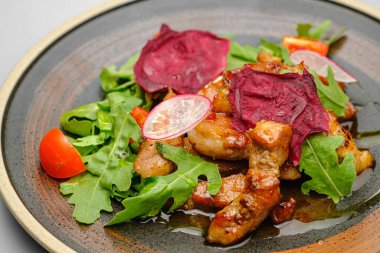 Soslu ızgara et ve beyaz tabakta sebze..