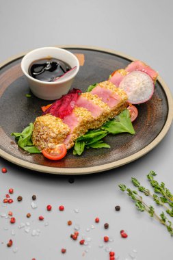 Beyaz tabakta soslu susamlı ton balığı..