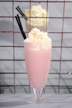 Krem şantili çilekli milkshake ve barda bir tüp.