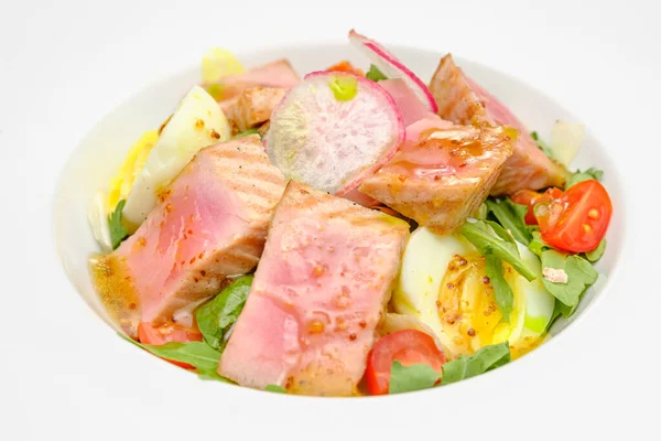 Салат з тунцем з яйцем, помідорами та салатом на білій тарілці. Обід у ресторані . — стокове фото