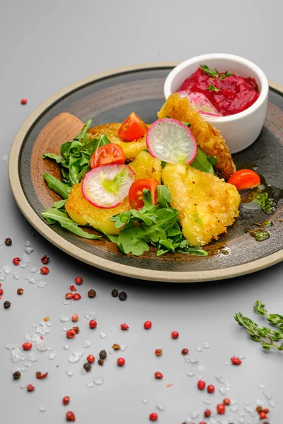 Fried french fries breaded with greens, radishes and beet chips on a white plate. — Stock Photo, Image