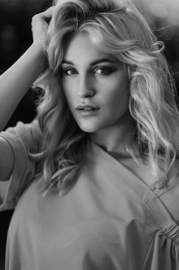 21 yaşında, mavi bir yaz elbisesi içinde beyaz kemer çantalı güzel bir kızın portresi. Kadın gülümsüyor. Güzel dudaklar ve gözler. Uzun gevşek saçlar.