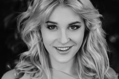 21 yaşında, mavi bir yaz elbisesi içinde beyaz kemer çantalı güzel bir kızın portresi. Kadın gülümsüyor. Güzel dudaklar ve gözler. Uzun gevşek saçlar.