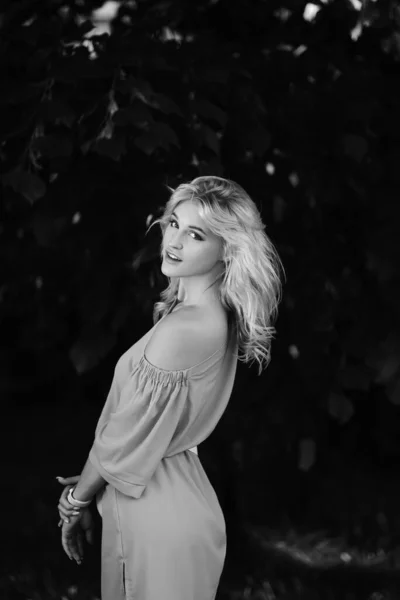 Retrato de uma menina bonita jovem 21 anos de idade em um vestido de verão azul com um saco de cinto branco. A mulher sorri. Lindos lábios e olhos. Cabelo longo e solto. — Fotografia de Stock