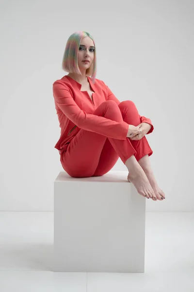 Portrait of a young beautiful informal blonde girl with dyed hair. Red jacket suit on the naked body. Studio photoshoot on a white background. — Stock Photo, Image