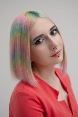Gayri resmi sarışın ve boyalı saçlı güzel bir kızın portresi. Çıplak vücutta kırmızı ceket var. Beyaz arkaplandaki stüdyonun fotoşopu.