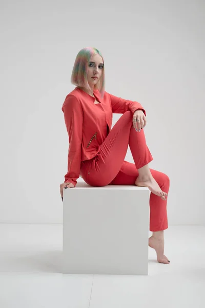 Portrait of a young beautiful informal blonde girl with dyed hair. Red jacket suit on the naked body. Studio photoshoot on a white background. — Stock Photo, Image