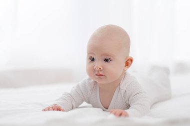 Güzel bir bebeğin portresi, beyaz pijamalı, beyaz gözlü, pencereye dayalı..