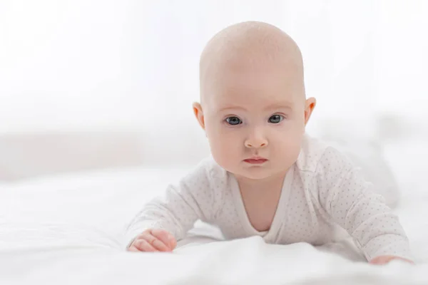 Güzel bir bebeğin portresi, beyaz pijamalı, beyaz gözlü, pencereye dayalı..