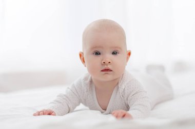 Güzel bir bebeğin portresi, beyaz pijamalı, beyaz gözlü, pencereye dayalı..