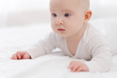 Güzel bir bebeğin portresi, beyaz pijamalı, beyaz gözlü, pencereye dayalı..