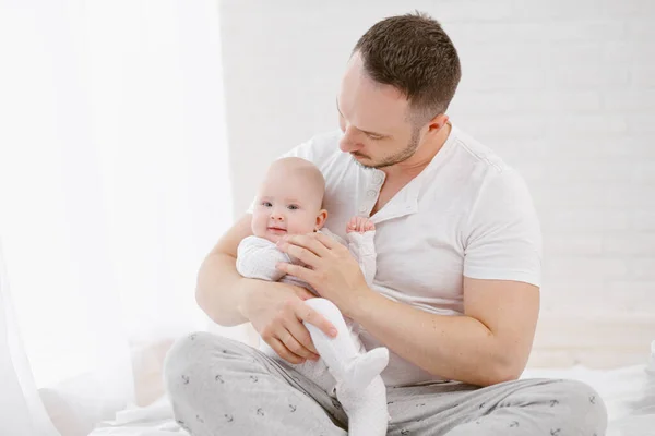 Un giovane padre tiene in braccio una neonata. — Foto Stock