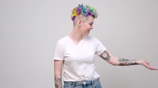 明るい色の染めの髪と短いヘアカットを持つ2人の若い女の子。白い背景に対して美容師のカラーリストとモデルのポーズ。同性愛者のレズビアンカップル. — ストック動画