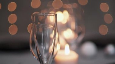 Şenlikli servis edilen yemek masası. Güzel yemekler, masa örtüleri, şarap bardakları ve gri tabaklar. Mumlar ve arka planda bir çelenk. Minimalist yemek odası dekorasyonu. Noel.