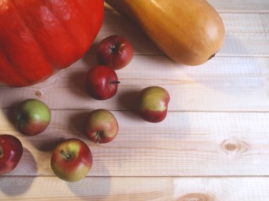 Ahşap arka planda balkabakları ve elmalar