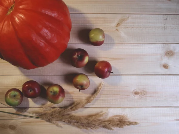 Balkabağı, çivili balkabağı ve tahta arka planda elmalar — Stok fotoğraf