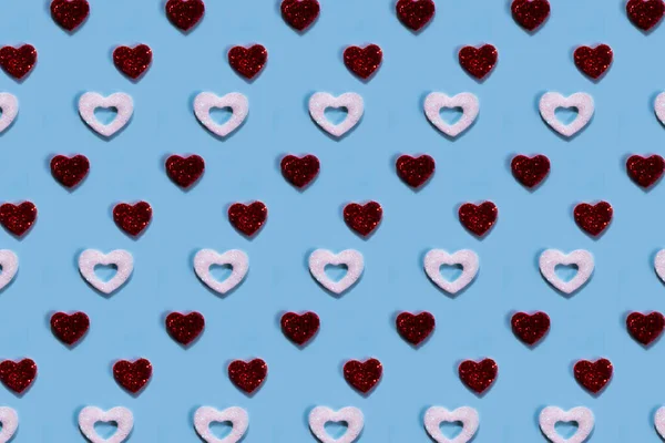 Rood en wit hartenpatroon op blauwe achtergrond. — Stockfoto
