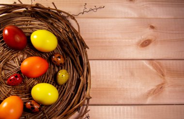 Tahta arka planda sepetteki Paskalya yumurtaları
