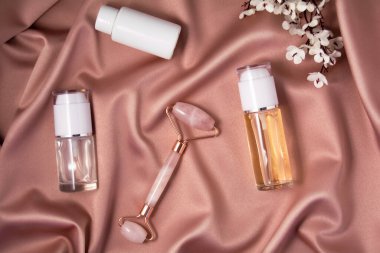 Parlak pembe kumaş üzerinde kuvars silindiri ve komedi ürünleri.