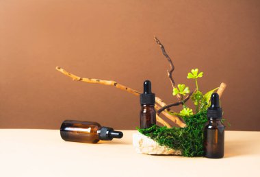 Serumlu şişe seti ya da kahverengi ve bej arka planda doğal malzemeli yağ seti