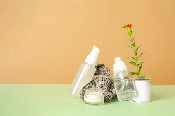 Frascos de cosméticos con gel u otro producto cosmético, piedras y flores —  Fotos de Stock