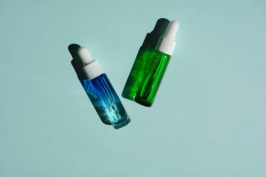 Cam şişelerde sıvı yüz serumu ve bir damlatıcı. Sağlık ve güzellik için cilt bakımının özü.