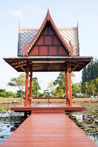 Bataklık ya da su birikintisi ahşap lake Pavyonu ile Tayland lotus ve yeşil yaprak
