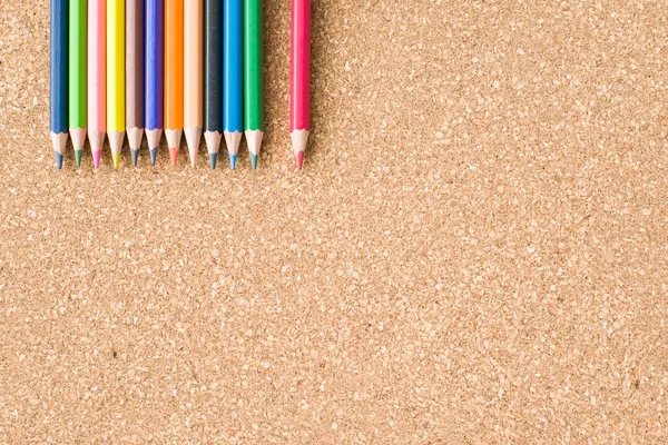 Colour pencils on cork board background close up — Stock Photo, Image