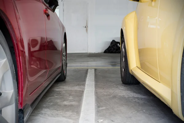 Tiny space between red  and yellow car in urban car park — Stock Photo, Image
