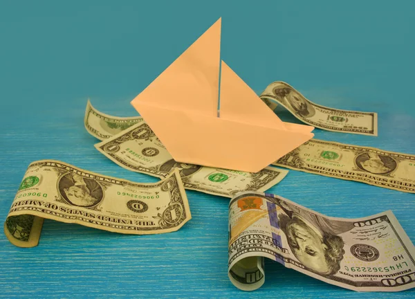 Paper boat on the waves in the sea of money — Stock Photo, Image