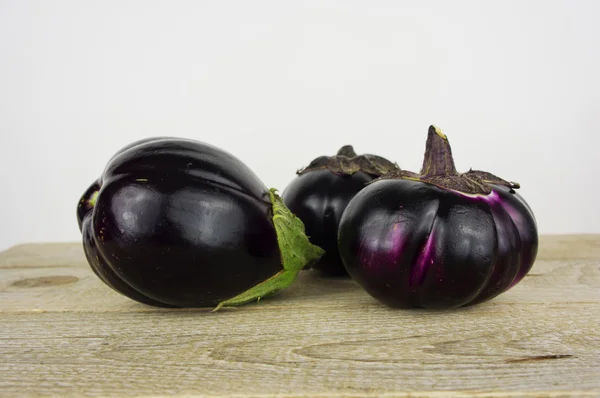 Läckra färska äggplantor på gamla träbord, höstens skörd. — Stockfoto