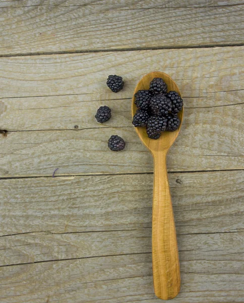 Blackberries with spoon on wooden background closeup shot — Stock Photo, Image