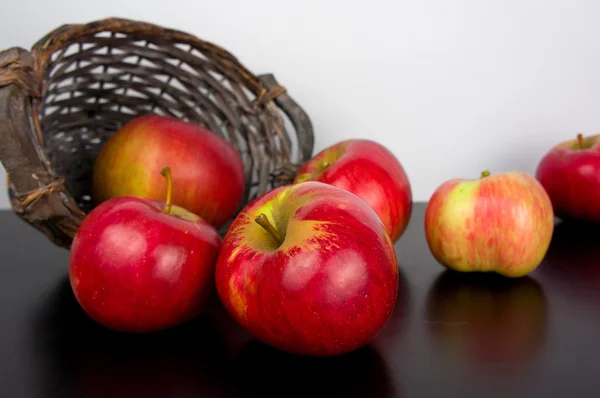 Red apples in basket on black wooden background — Stock Photo, Image