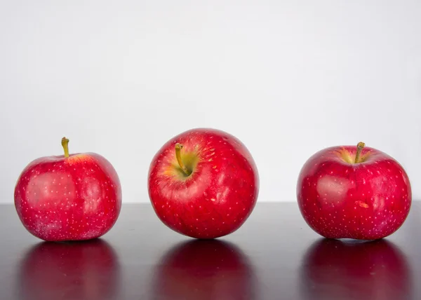 Siyah bir arka plan yansıması ile üç elma — Stok fotoğraf