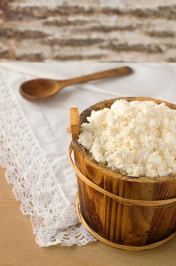 Ahşap masa üzerinde bir kase süzme peynir