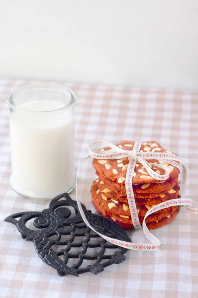 Biscotti su un tavolo con un bicchiere di latte — Foto Stock