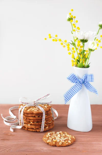 Bouquet of spring flowers on the table and cookies — Stock Photo, Image