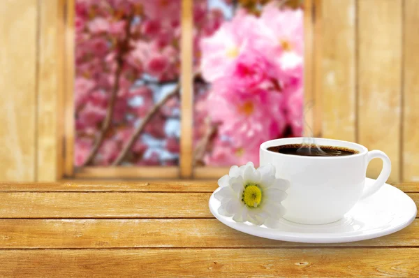 Чашка кофе на столе с видом на окно — стоковое фото