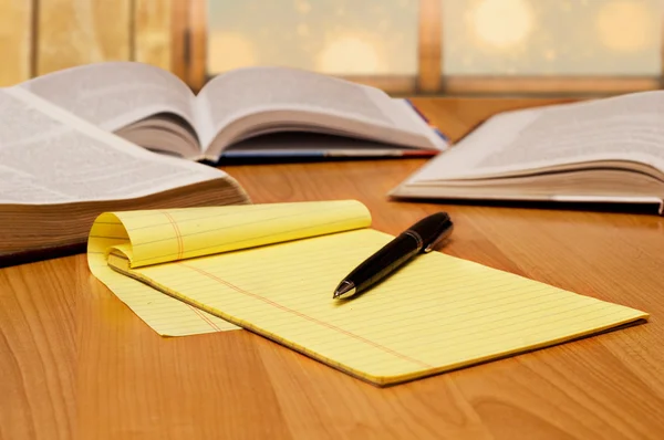 Yellow legal pad on the table with books — Stock Photo, Image