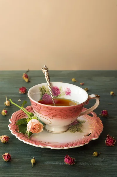 Nahaufnahme einer Tasse Tee mit Rosen auf einem Holztisch — Stockfoto
