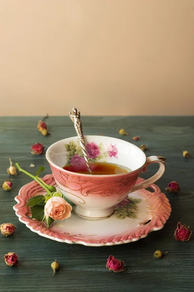 bir fincan çay ile gül ahşap masa üzerinde yakın çekim