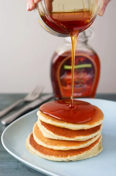 Maple siroop gieten op pannenkoeken. — Stockfoto