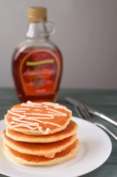 Stapel van heerlijke pannenkoeken met honing op plaat geïsoleerd op whit — Stockfoto